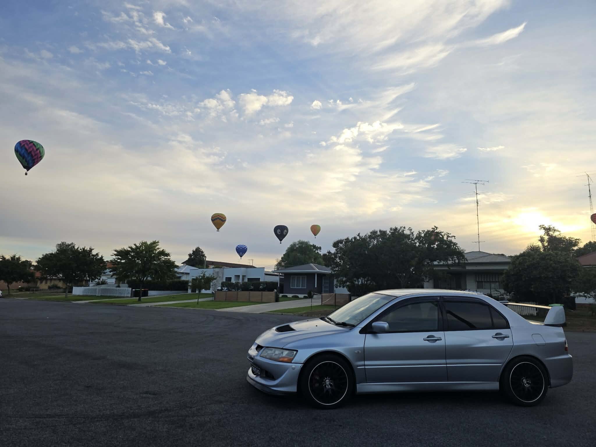 2003 Mitsubishi Lancer Evolution VIII in Apex Silver, side on at sunrise with hot air balloons over Leeton, NSW