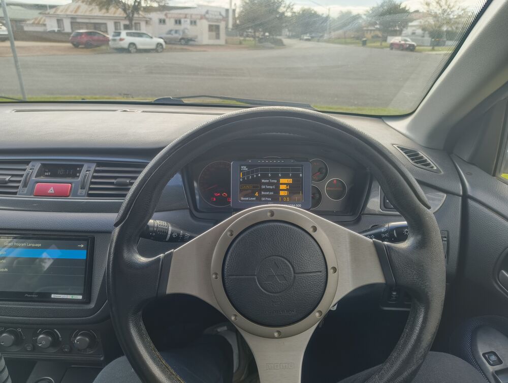 Cockpit from the driver's eye — OEM Momo wheel, Plex SDM300 in the cluster, Pioneer head unit